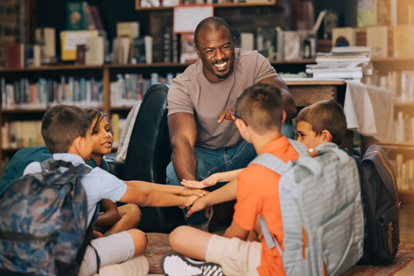 Team of students each put a hand in the center of a circle