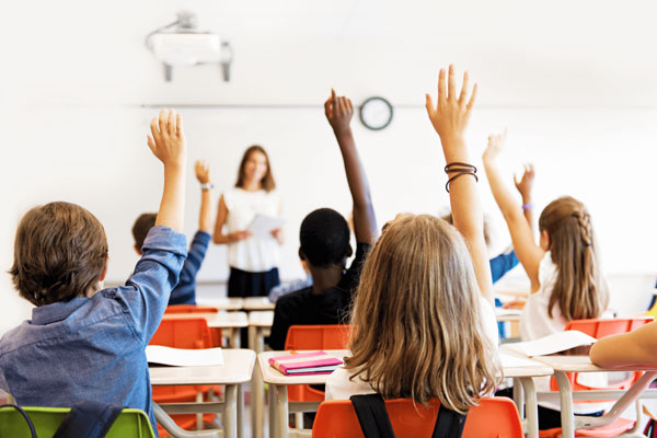 Elementary students raising their hands