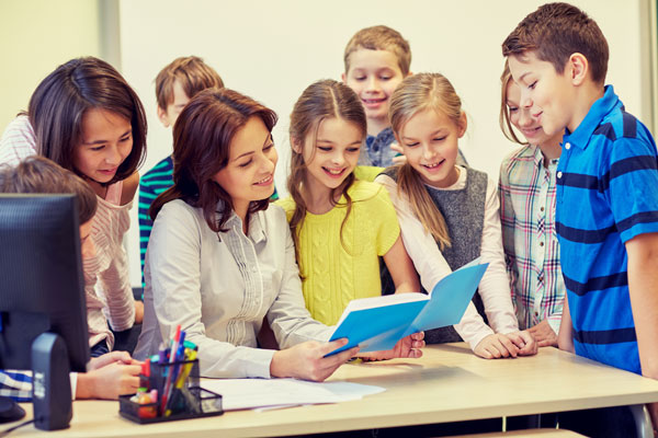 Teacher showing a group of elementary students a book