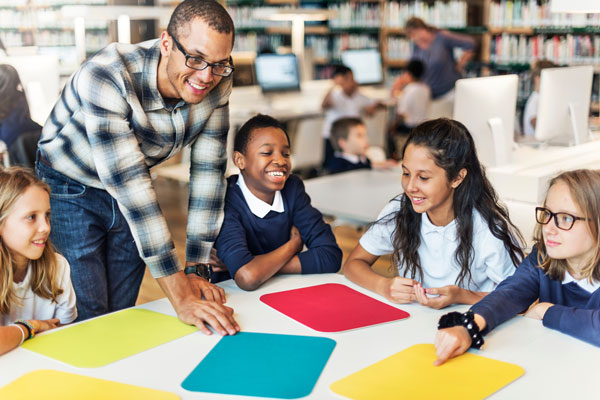 Teacher helping a group of students with a project