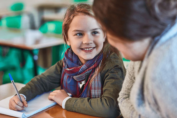 Elementary student smiling at her teacher