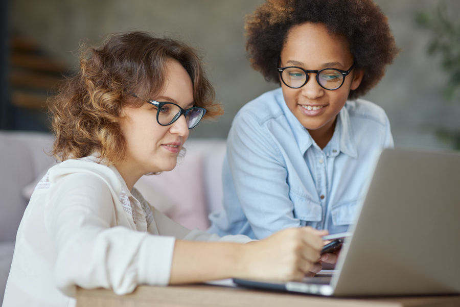 Female teacher helping her student on her laptop