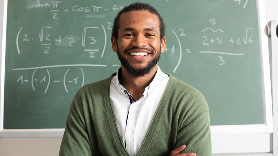 Math teacher in front of chalkboard