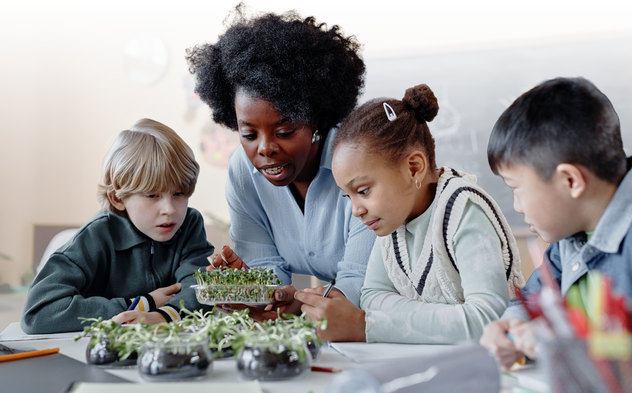 Teacher and students observing plants in a science classroom